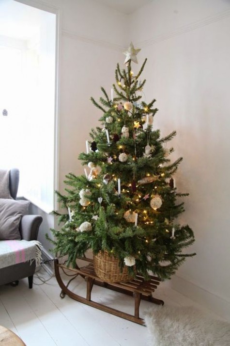 #Small #Christmas #Tree tree decorated with pompoms, pinecones and candles placed in a basket and on a sleigh