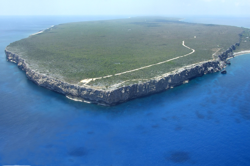 Climb a limestone bluff overlooking the sea in Cayman Brac