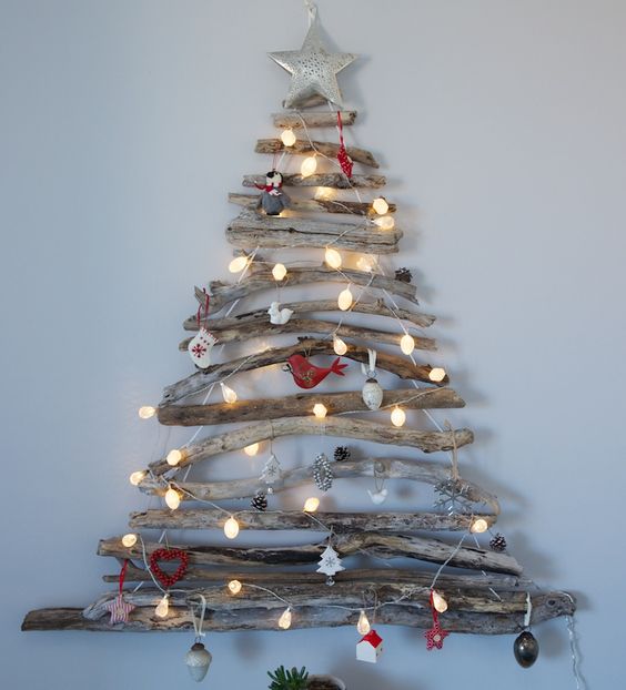 Exclusive driftwood Christmas tree decorated with lights and ornaments.