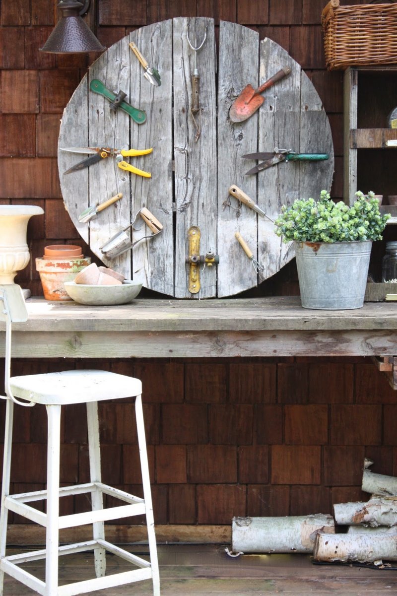 Faux outdoor clock made from old rusted gardening tools.