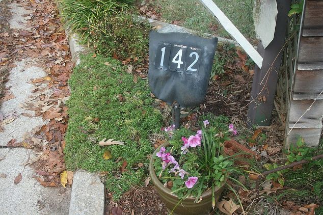 Old shovel repurposed into outdoor address sign.