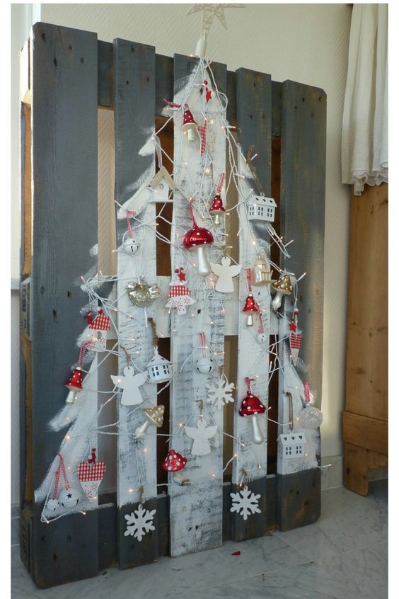 Recycled and white painted pallet tree decorated with beautiful Christmas ornaments.