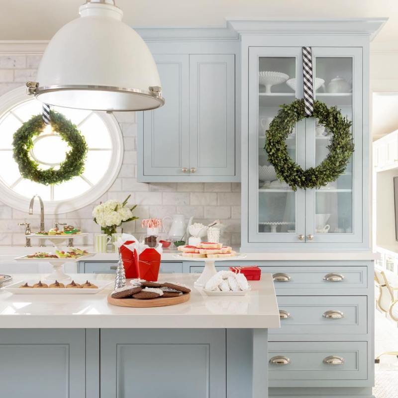 Blue cabinets light pale christmas wreaths.