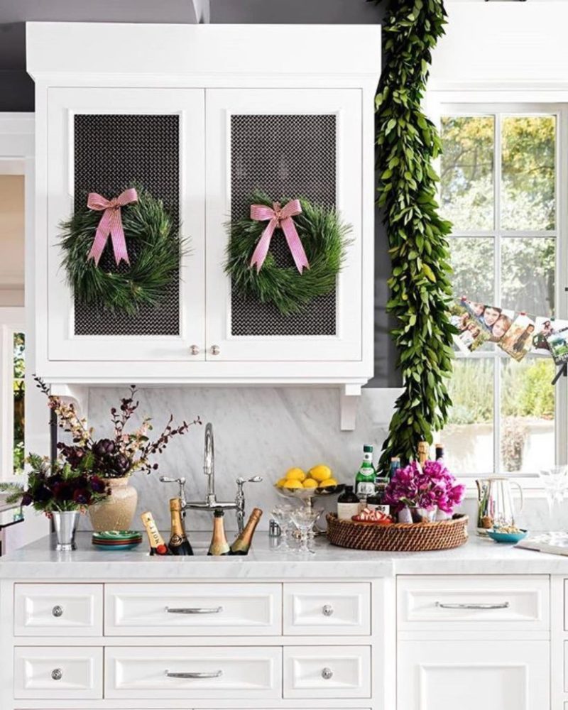 Pink christmas bows wreath white marble kitchen.