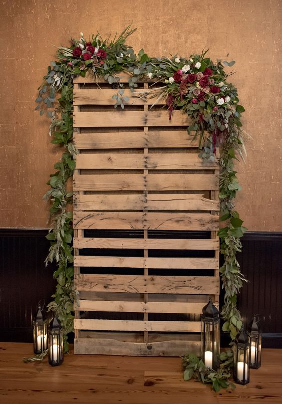 Reclaimed pallet booth decorated with fresh leaves and flowers.