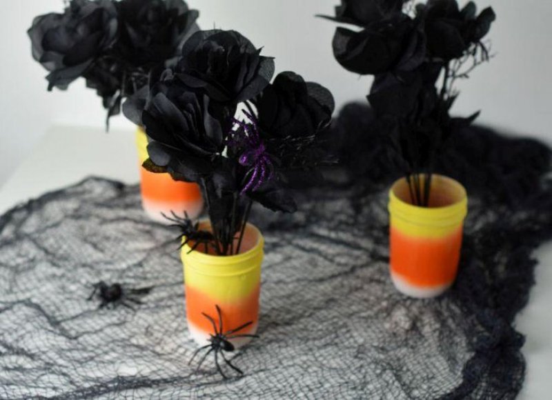 DIY candy corn centerpiece with spiders and black roses.