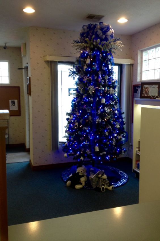 Blue and sliver slim line Christmas tree with sparkling clear lights.