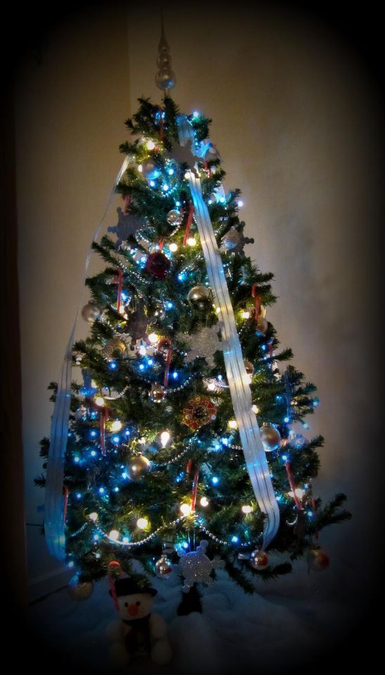 Silver, blue and white Christmas tree with homemade sparkly snowflake ornaments.
